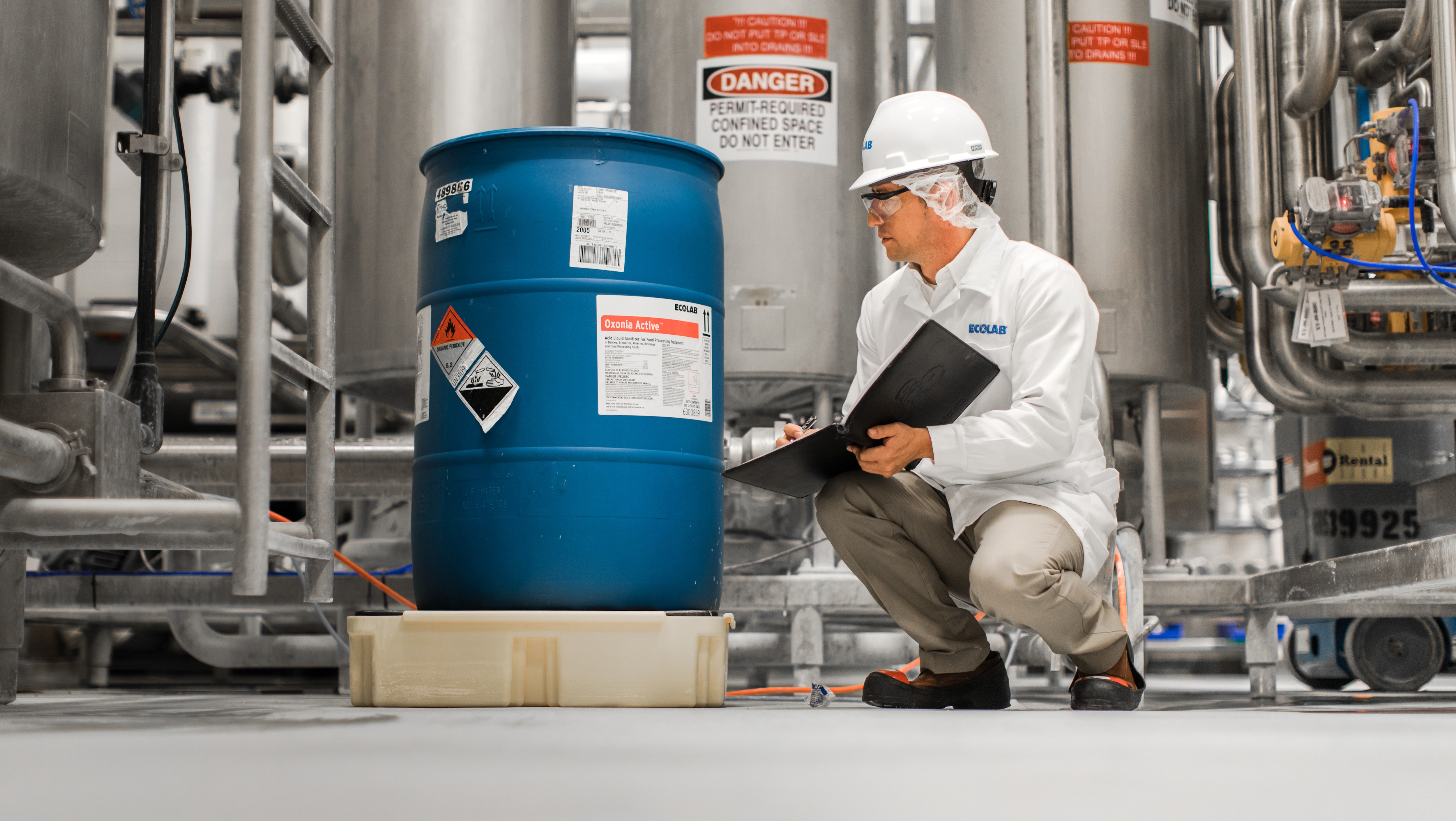 Ecolab technician looking at a barrel of chemicals
