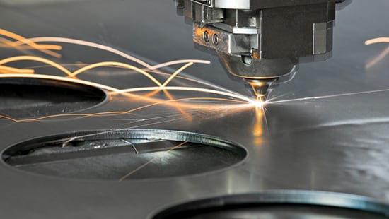Laser cutter cutting circles out of metal sheet.