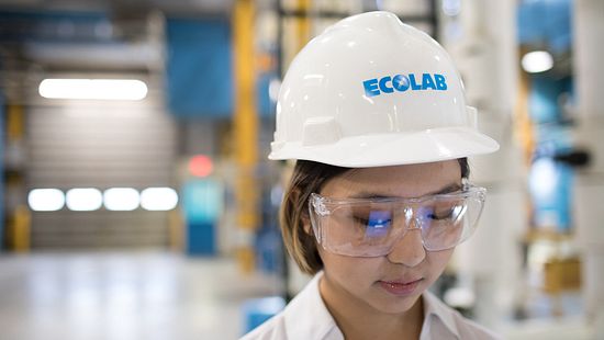 Woman wearing hard hat and goggles in power plant - Ecolab