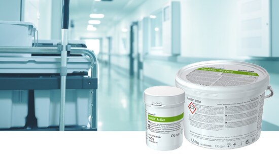 Hospital corridor with a cleaning cart and surface disinfectant containers in the foreground.