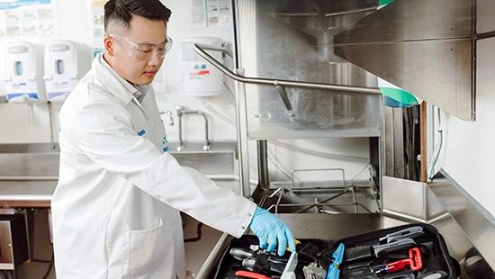 Person Holding Stack of Plates in Commercial Kitchen